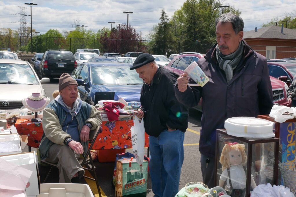 Two men near a stand in the Skokie Park District's flea market on May 2.